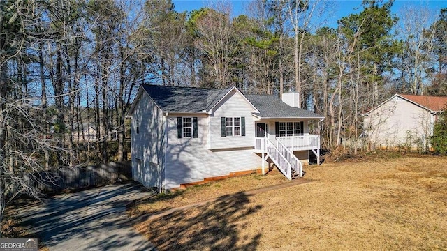 single story home featuring stairs, a chimney, and a front lawn