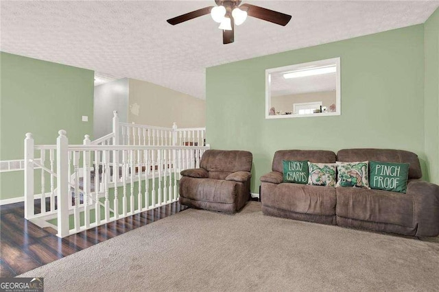 living room featuring a ceiling fan, carpet, and a textured ceiling