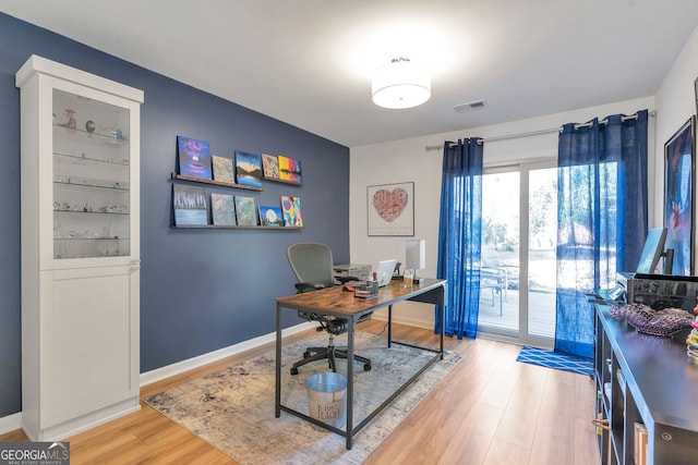 office featuring visible vents, light wood-style flooring, and baseboards