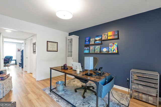 office with light wood-style flooring and baseboards