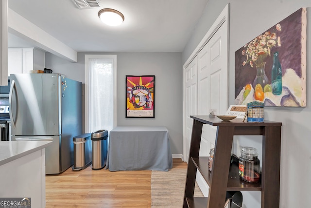 kitchen featuring stainless steel appliances, light countertops, visible vents, and light wood-style flooring