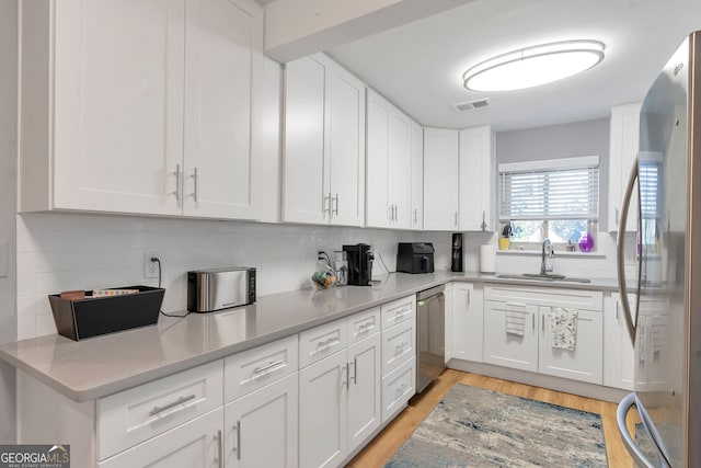 kitchen with white cabinetry, visible vents, appliances with stainless steel finishes, and a sink