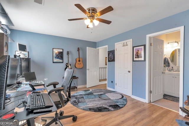 office area with ceiling fan, wood finished floors, visible vents, and baseboards