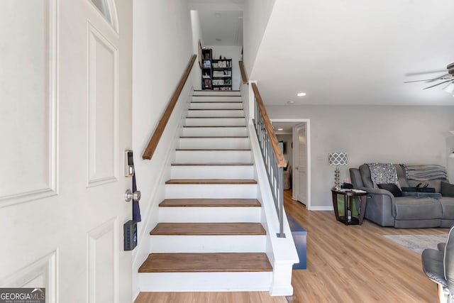 stairs featuring ceiling fan, baseboards, wood finished floors, and recessed lighting