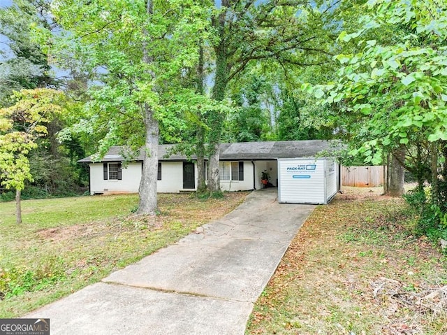 single story home with a front yard, driveway, and fence