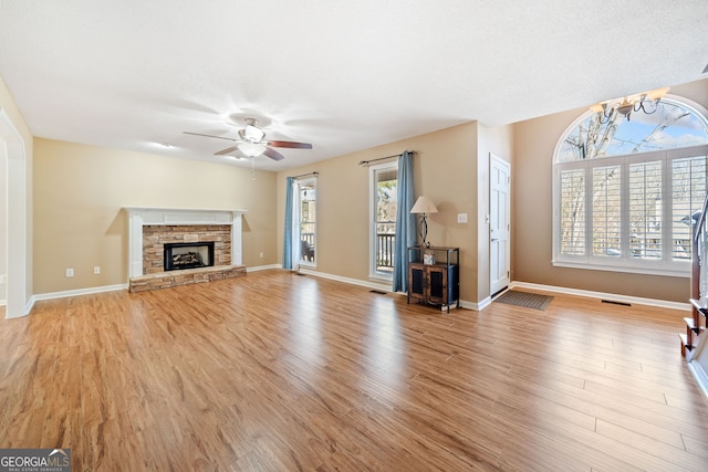 unfurnished living room featuring light wood-style floors, a fireplace, and baseboards