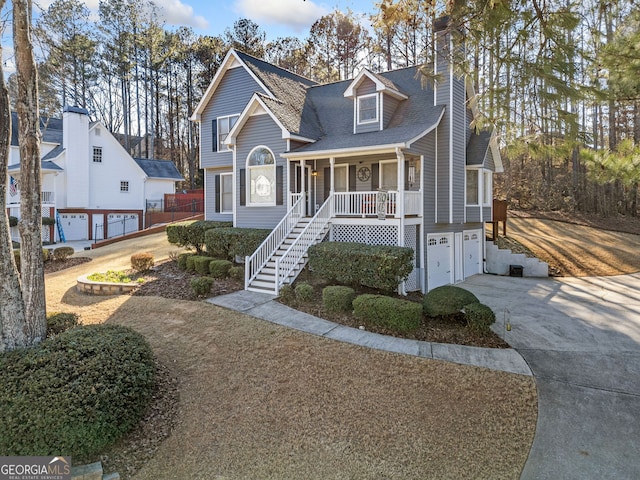 view of front of house featuring covered porch, a garage, stairs, concrete driveway, and a chimney