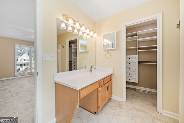 full bath with baseboards, a spacious closet, and vanity