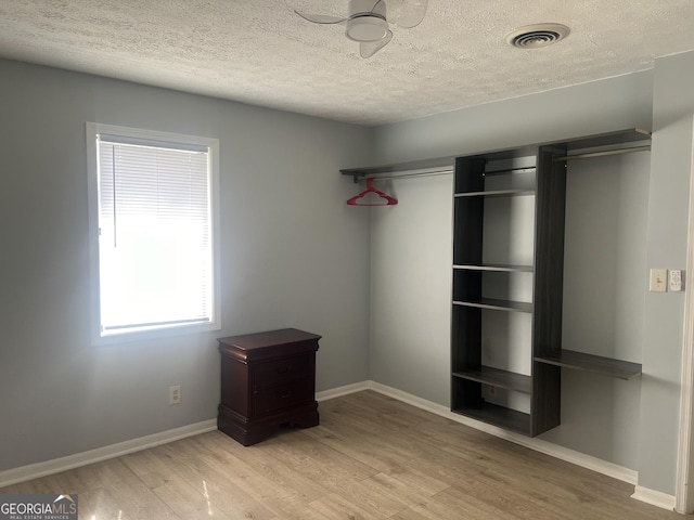 unfurnished bedroom featuring baseboards, visible vents, and wood finished floors