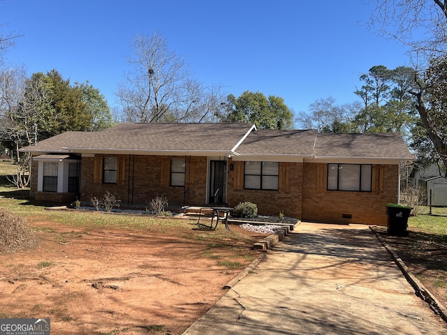 ranch-style home featuring crawl space, brick siding, and roof with shingles