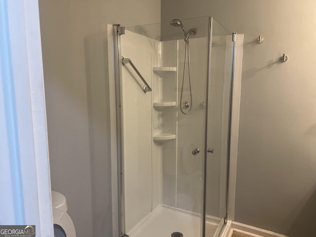 bathroom with a shower stall and toilet