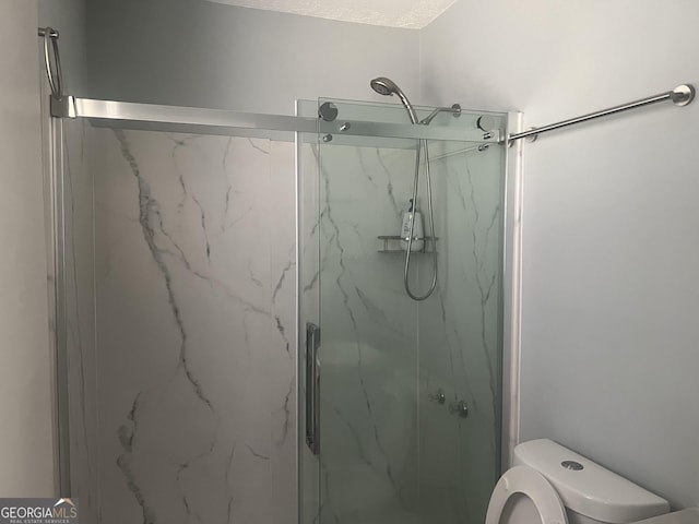 full bath featuring a marble finish shower and toilet