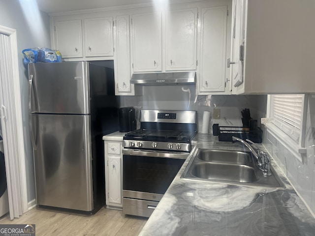 kitchen featuring under cabinet range hood, appliances with stainless steel finishes, white cabinets, and a sink