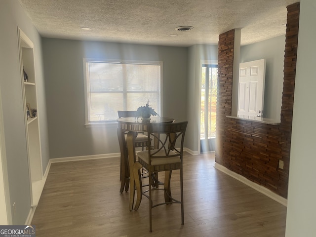 dining room with wood finished floors, visible vents, and baseboards