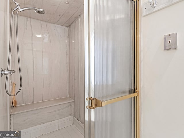 bathroom featuring a marble finish shower