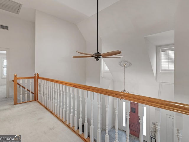 hall featuring high vaulted ceiling, visible vents, carpet flooring, and an upstairs landing