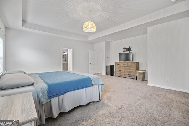 bedroom with baseboards, a tray ceiling, and carpet flooring