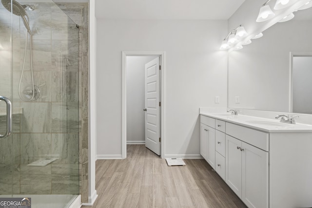 full bathroom with wood finished floors, a stall shower, and a sink