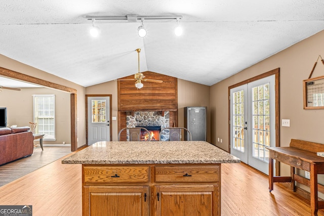 kitchen with lofted ceiling, open floor plan, a fireplace, and plenty of natural light