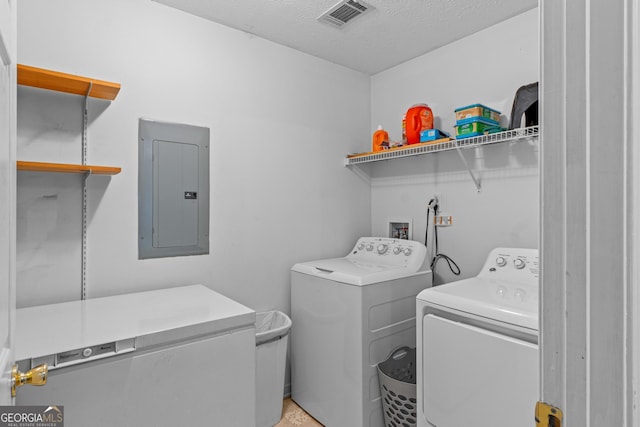 washroom featuring visible vents, washing machine and dryer, a textured ceiling, laundry area, and electric panel