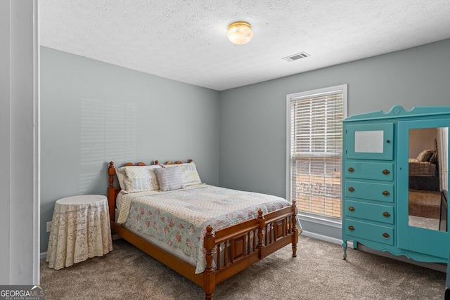 bedroom with baseboards, carpet, visible vents, and a textured ceiling