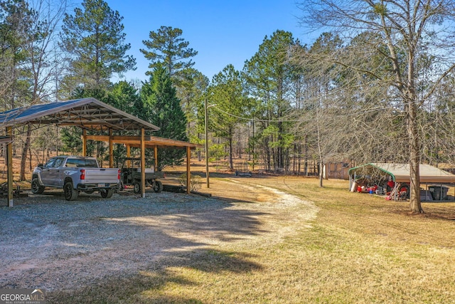 view of parking with gravel driveway and a detached carport