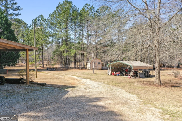 view of yard featuring an outbuilding, a carport, and a storage unit