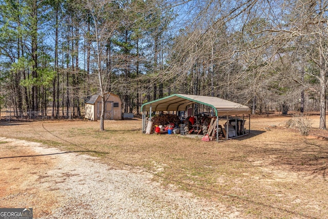 view of yard with a carport, an outdoor structure, and a storage unit