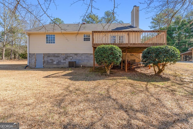 rear view of property with cooling unit, a yard, crawl space, a wooden deck, and a chimney