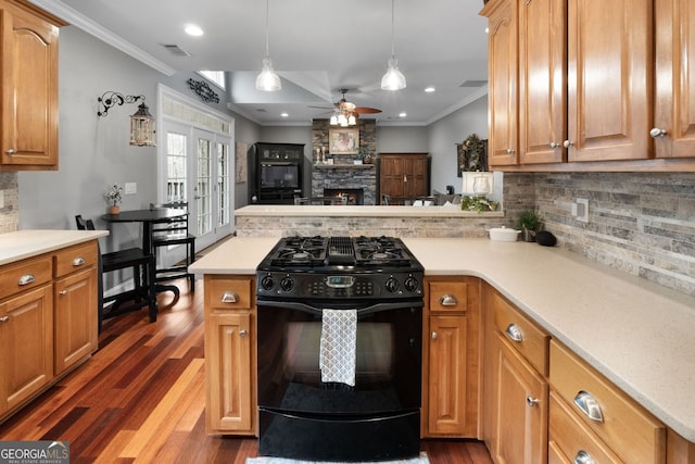 kitchen with a peninsula, a fireplace, ornamental molding, and gas stove