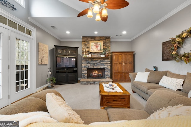 carpeted living area featuring ornamental molding, visible vents, a stone fireplace, and baseboards