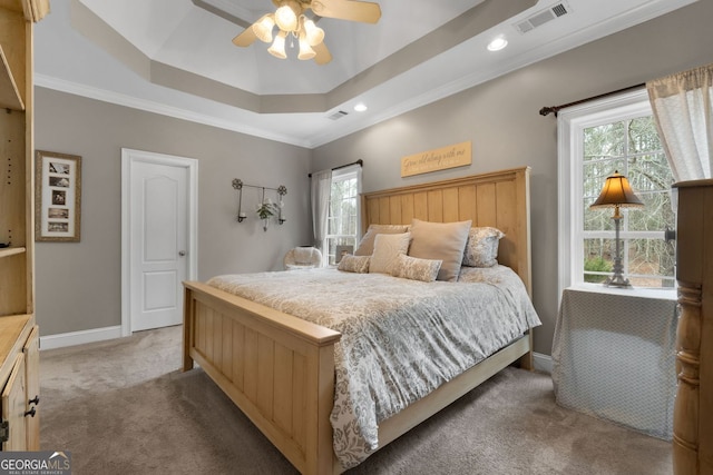 bedroom featuring a tray ceiling, crown molding, light colored carpet, visible vents, and baseboards