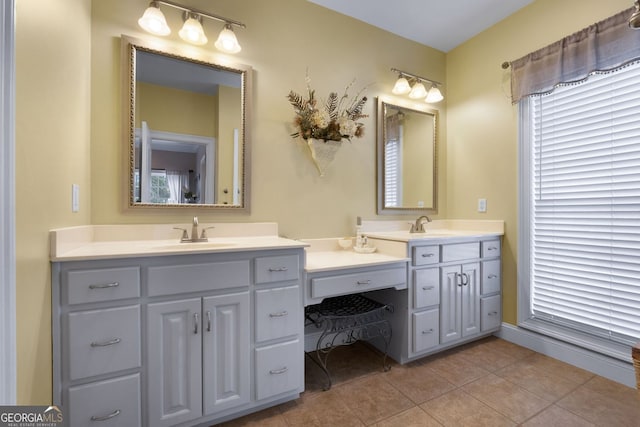 bathroom featuring double vanity, a sink, and tile patterned floors