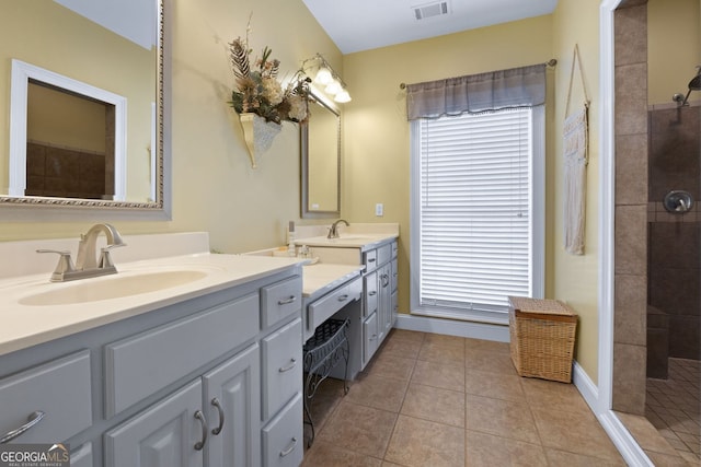 bathroom with visible vents, vanity, a walk in shower, baseboards, and tile patterned floors