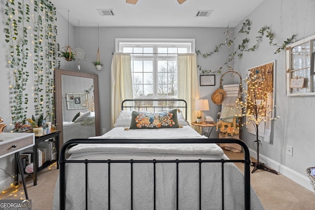 carpeted bedroom featuring visible vents, ceiling fan, and baseboards