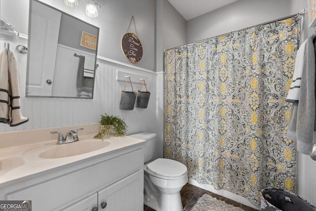 bathroom featuring curtained shower, tile patterned flooring, vanity, and toilet