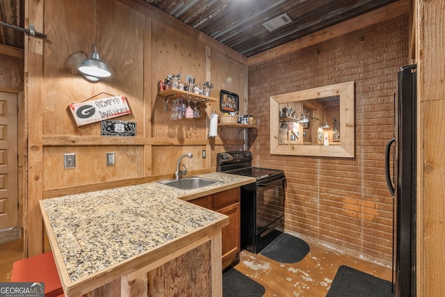 bar featuring visible vents, a sink, wooden walls, black range with electric cooktop, and fridge