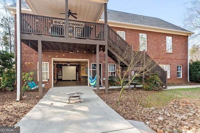 exterior space featuring a ceiling fan, concrete driveway, stairway, an attached garage, and brick siding