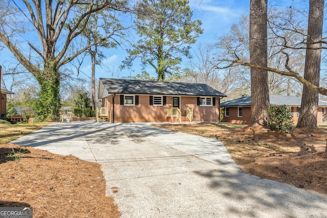 view of front of house featuring concrete driveway and brick siding