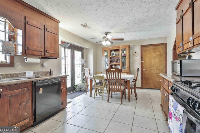 kitchen with range with gas cooktop, black dishwasher, light tile patterned floors, stainless steel microwave, and visible vents