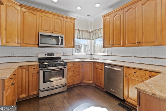 kitchen featuring visible vents, dark wood finished floors, appliances with stainless steel finishes, light stone counters, and a sink