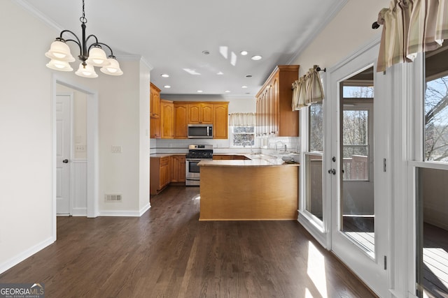 kitchen featuring visible vents, appliances with stainless steel finishes, ornamental molding, dark wood-type flooring, and a peninsula