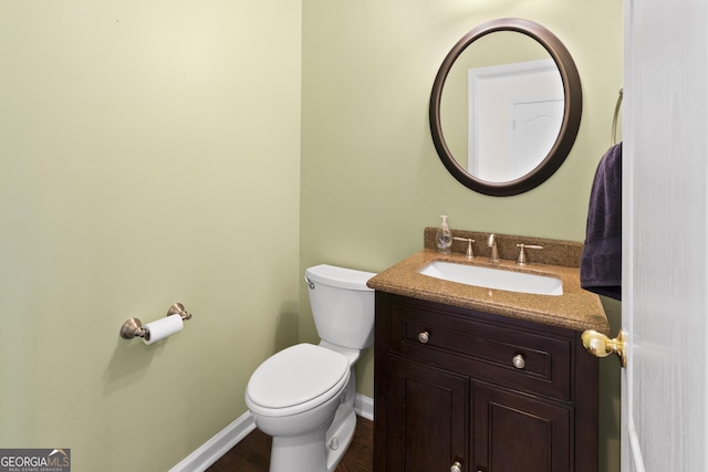 bathroom featuring vanity, toilet, and baseboards