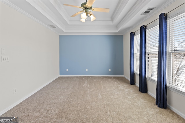 spare room featuring baseboards, visible vents, a raised ceiling, and crown molding