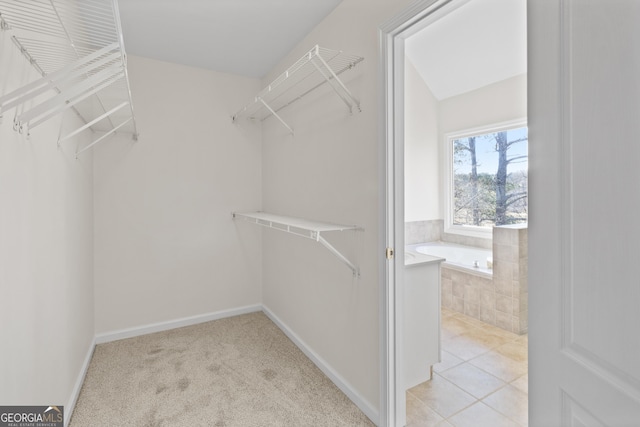 walk in closet featuring light tile patterned floors and light colored carpet