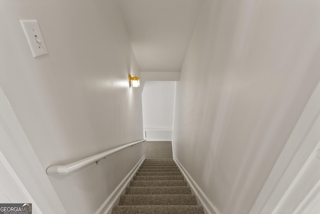 staircase featuring carpet floors and baseboards