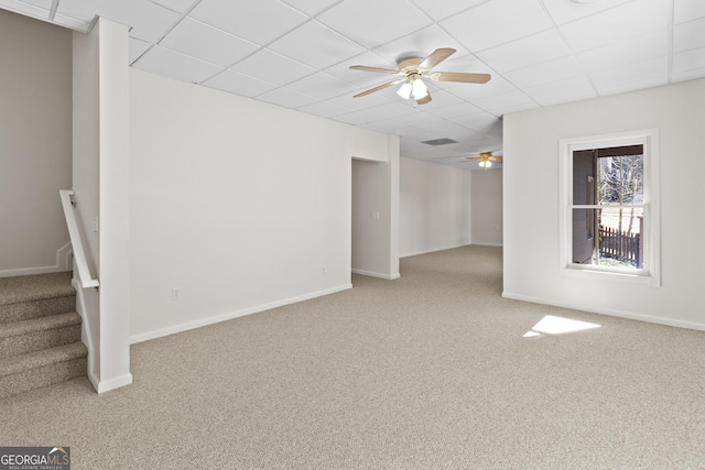 basement with carpet, a paneled ceiling, baseboards, and stairs