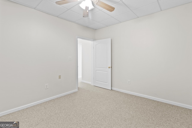 empty room featuring ceiling fan, carpet flooring, a paneled ceiling, and baseboards