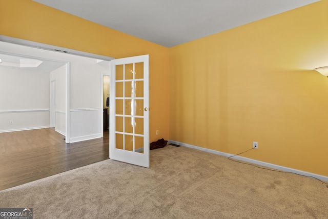 carpeted empty room featuring french doors