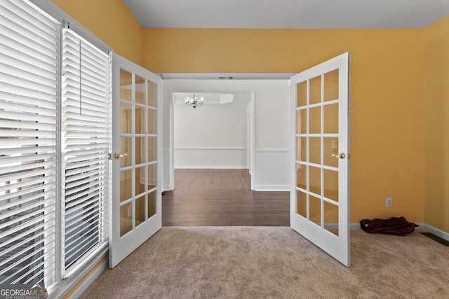 doorway to outside featuring an inviting chandelier, carpet flooring, and french doors